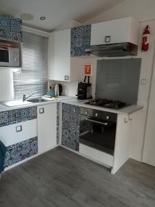 a kitchen with white cabinets and a stove top oven at Mobile Home Service Hotelier in Fréjus