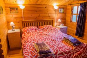 a bedroom with a bed in a log cabin at Le Chalet De Louyère in Saint-Salvadour