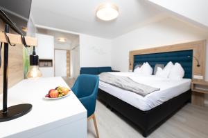 a hotel room with a bed and a bowl of fruit on a table at Maria Theresien Hof Loipersdorf in Jennersdorf