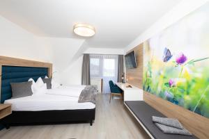 イェナースドルフにあるMaria Theresien Hof Loipersdorfのベッドとデスクが備わるホテルルームです。