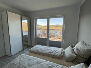 ein Schlafzimmer mit einem Bett und einem großen Fenster in der Unterkunft Ferienhaus Diemelblick in Heringhausen