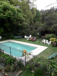 a swimming pool with chairs and tables and chairs at Cabaña La Strega in Tandil
