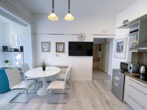 uma cozinha e sala de jantar com uma mesa branca e cadeiras em Top Art Topusko Apartments em Topusko