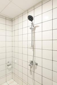a shower in a white tiled bathroom at HOTEL THE WHITE HOUSE Plovdiv in Plovdiv +61 photos