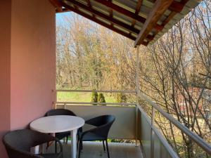 d'un balcon avec une table, des chaises et une fenêtre. dans l'établissement Top Art Topusko Apartments, à Topusko