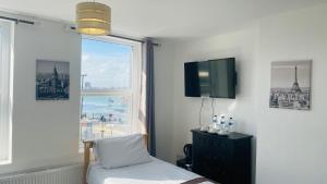 a room with a window and a bed and a tv at Lady Hamilton Public House B&B in Portsmouth