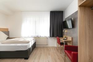 a hotel room with a bed and a table and a tv at Zur Blume Hotel & Restaurant Efringen-Kirchen bei Basel in Efringen-Kirchen