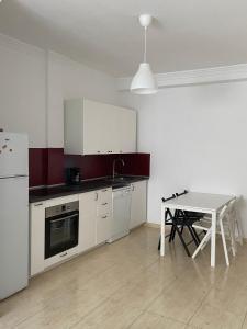 Una cocina con una mesa y un refrigerador blanco. en Apartamento cerca de las piscinas naturales, en Punta Mujeres