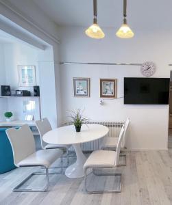 biała jadalnia z białym stołem i krzesłami w obiekcie Top Art Topusko Apartments w mieście Topusko