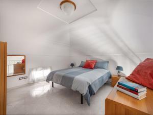 La Perla di Chicca في بوسيتانو: غرفة نوم بسرير وطاولة مع كتب