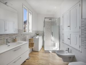 ein weißes Badezimmer mit einem Waschbecken und einem Kühlschrank in der Unterkunft La Perla di Chicca in Positano