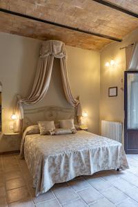 een slaapkamer met een groot bed met een baldakijn bij Wine Resort Colsereno in Montalcino