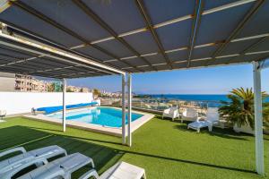 a patio with a pool and chairs and the ocean at Vistamar Luxury Apartments By DLV -Adults Only- in Villajoyosa