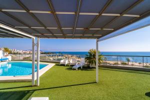 a patio with a pool and a view of the ocean at Vistamar Luxury Apartments By DLV -Adults Only- in Villajoyosa