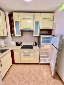 a kitchen with white cabinets and an open refrigerator at SUSHI metro WiFi 500 MBs, 70’TV Netflix AppleTV+ in Warsaw