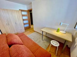 a living room with a couch and a table at SUSHI metro WiFi 500 MBs, 70’TV Netflix AppleTV+ in Warsaw