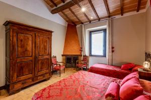 a bedroom with two beds and a large wooden cabinet at Wine Resort Colsereno in Montalcino