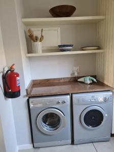 a kitchen with a washer and a washing machine at Caribbeans Estates 76/34 in Port Edward