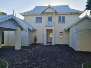 a large white house with a driveway at Caribbeans Estates 76/34 in Port Edward