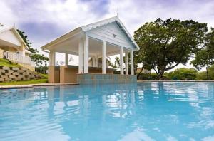 a pool with a gazebo next to a house at Caribbeans Estates 76/34 in Port Edward