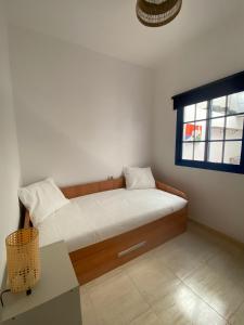 Un dormitorio con una cama con una mesa y una ventana. en Apartamento cerca de las piscinas naturales, en Punta Mujeres 1 foto más