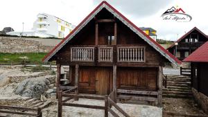 ein kleines Holzhaus mit rotem Dach in der Unterkunft Chalé Avô Alfredo in Cortes do Meio