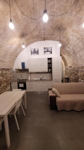 ein Zimmer mit einem Sofa und einem Tisch sowie einer Küche in der Unterkunft Casa Vittoria in Palazzolo Acreide
