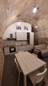 een keuken en een woonkamer met een tafel en een bank bij Casa Vittoria in Palazzolo Acreide