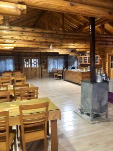 a large room with wooden tables and a stove at OBA KÜTÜK EVLERi in Seben
