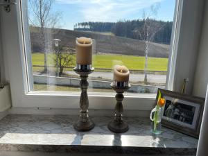 two candles on a table in front of a window at Ferienhaus Hopfental in Kelheim