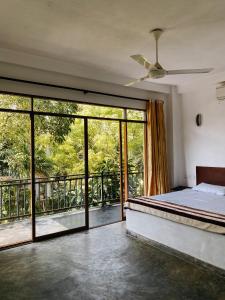 a bedroom with a bed and sliding glass doors at Karu's place in Hikkaduwa