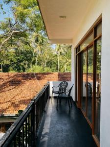 un balcón de una casa con una silla en Karu's place, en Hikkaduwa