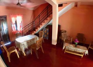 un soggiorno con tavolo, sedie e scala di Batti Relax Point a Batticaloa