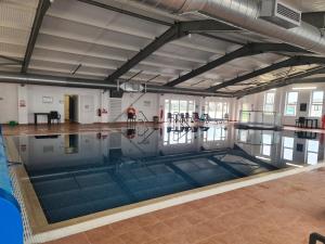 an empty swimming pool in a building with its floors and ceilings at Mawgan Pads Perranporth in Cubert