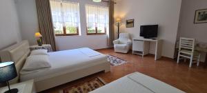 1 dormitorio con 1 cama y TV en una habitación en Veranda B&B, en Berat