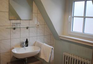 a bathroom with a sink and a window and a staircase at Gästehaus Weingut Schier im historischen Zehnthof in Reil