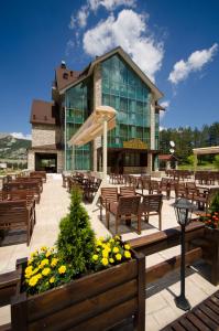 ein Gebäude mit vielen Stühlen und einem Regenschirm in der Unterkunft Hotel Monte Rosa in Cetinje