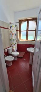 un bagno con due servizi igienici, due lavandini e una finestra di Veranda B&B a Berat Altre 28 foto
