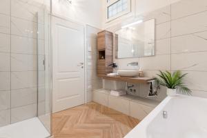 uma casa de banho com uma banheira, um lavatório e um espelho. em Classic Chic - Città Alta em Bérgamo