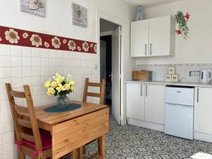 a kitchen with a table with a vase of flowers on it at La Maison Bleue in Préveranges