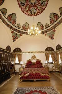 a bedroom with a bed with a chandelier in it at Cesme Kanuni Kervansaray Historical Hotel in Çeşme