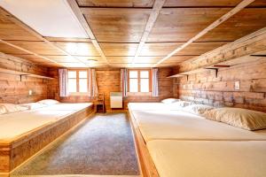 a room with three beds in a wooden room at Pfefferhütte in Marul