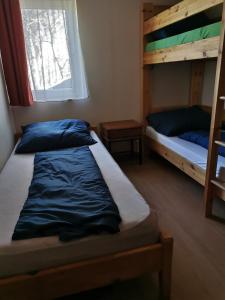 a bedroom with two bunk beds and a window at Strand Motel, Vígadó Csárda in Dombrád