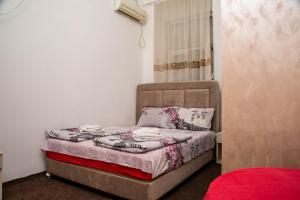 a small bedroom with a bed with pillows on it at Sobe sa sopstvenim KUPATILOM Private rooms bathroom In CENTER in Novi Sad