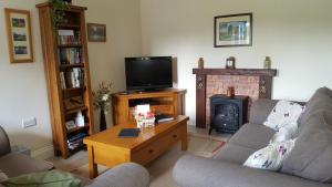 a living room with two couches and a fireplace at 1 Barge Cottage in Narborough