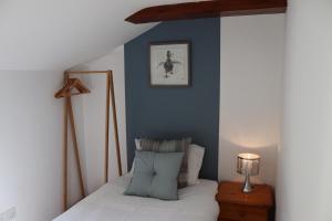 a bedroom with a bed with a blue wall at 1 Barge Cottage in Narborough