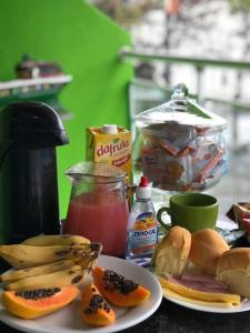 una mesa con dos platos de comida y algo de fruta en pousada do rei, en Pedra de Guaratiba