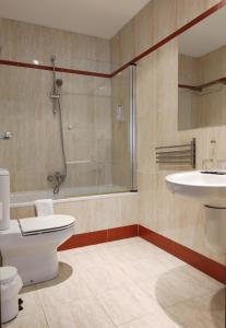 a bathroom with a shower and a toilet and a sink at Hotel Cuéntame in Burgos