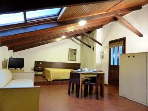 a room with a bed and a table and a room with a couch at Residence Green Park in Ventimiglia