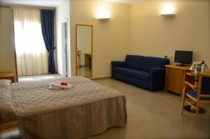 1 dormitorio con 1 cama y 1 sofá azul en Borgo Villa Maria, en Monticchio